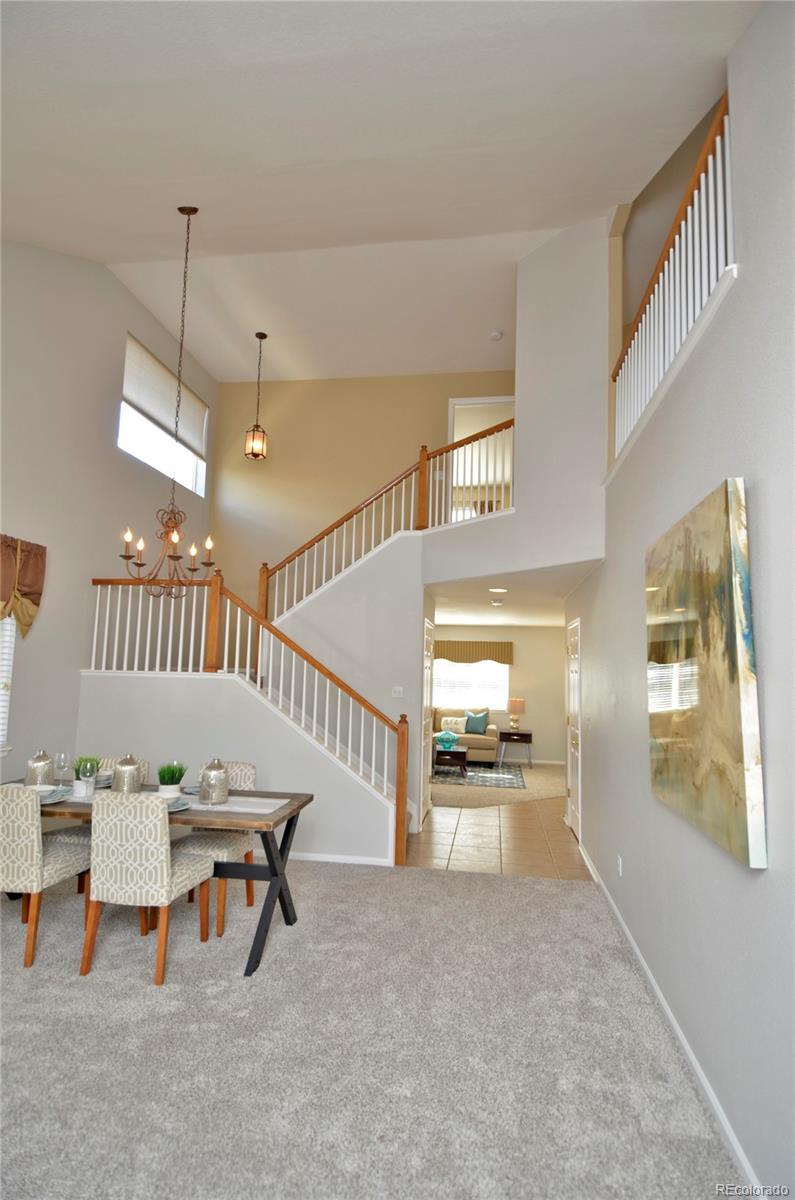 10699 Wynspire Way Highlands Ranch, CO 80130 - Photo 5 of 40 a living room with furniture and a dining table