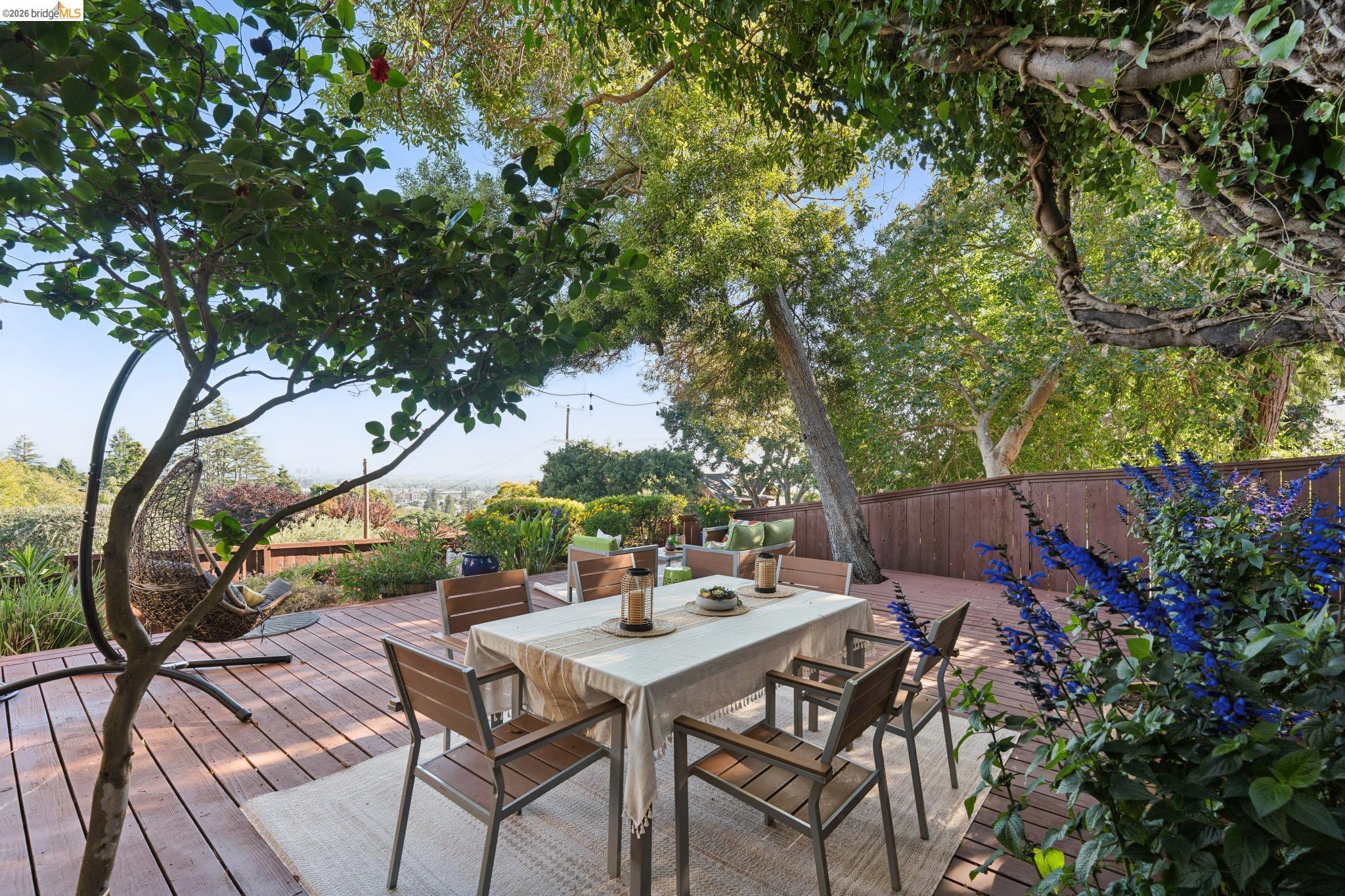 2301 Oak Street Berkeley, CA 94708 - Photo 37 of 61 Expansive outdoor decking features a privacy fence, lush mature trees, and vibrant blue flowering shrubs