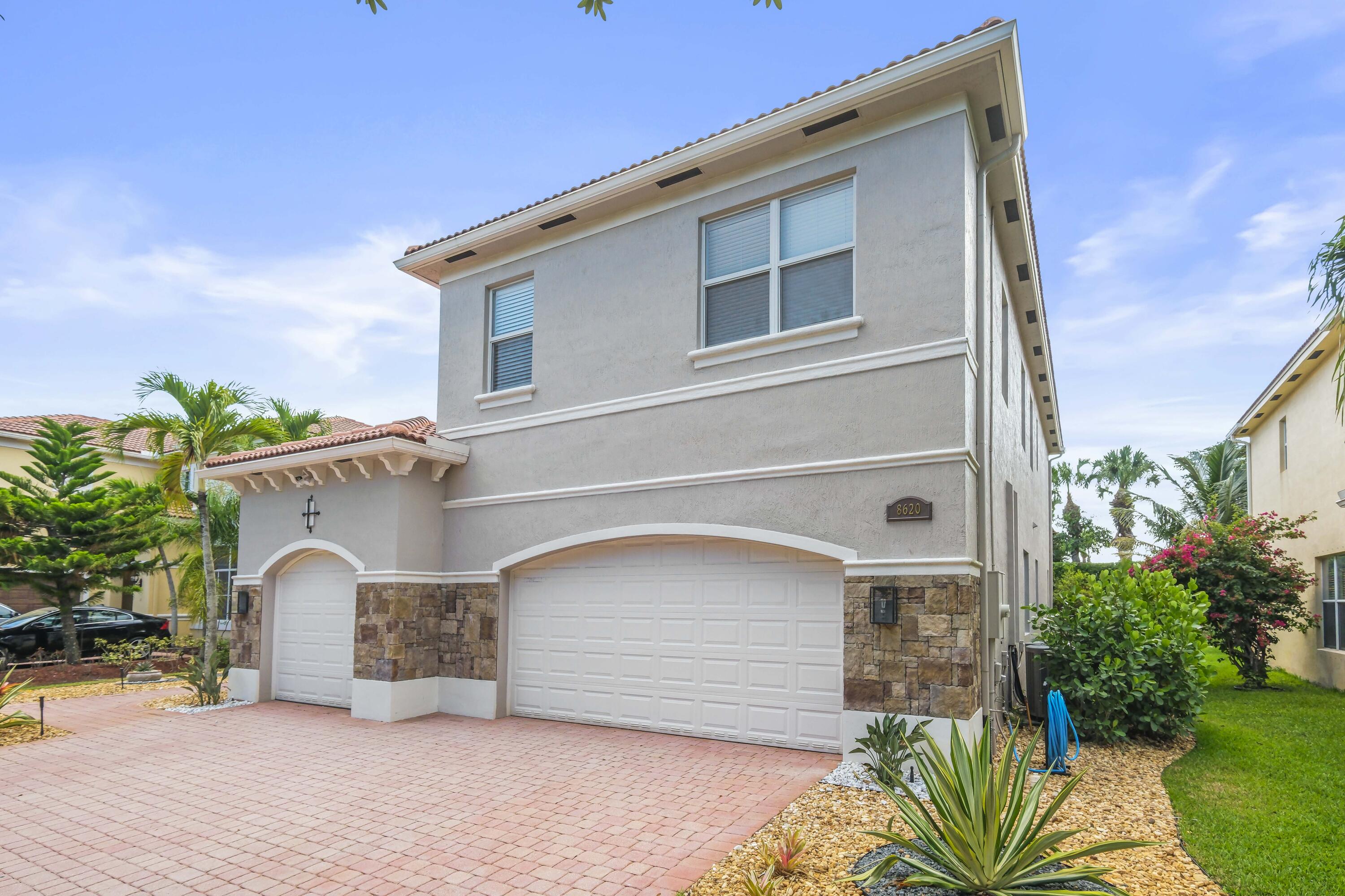 8620 Cobblestone Point Circle Boynton Beach, FL 33472 - Photo 3 of 42 a front view of a house with a yard and garage