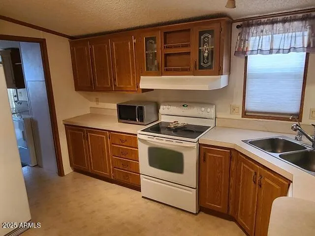 a kitchen with a stove sink and cabinets