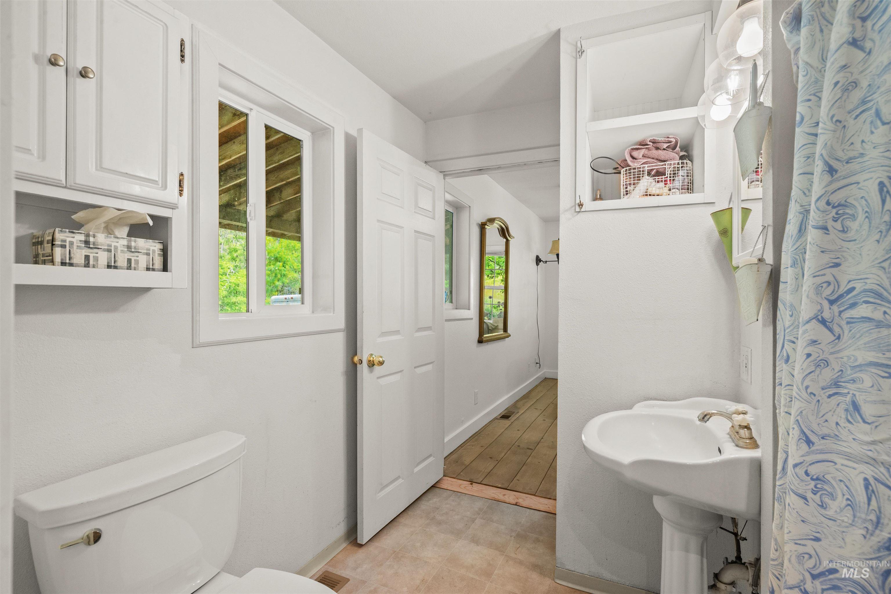 1314 Cedar Ridge Road Kendrick, ID 83537 - Photo 16 of 50 Pedestal sink with white ceramic basin, two panel doors, and a window
