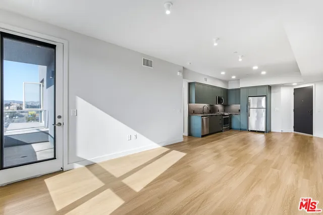 a view of a kitchen with a sink and a refrigerator