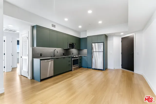 a kitchen with stainless steel appliances granite countertop a refrigerator and a sink