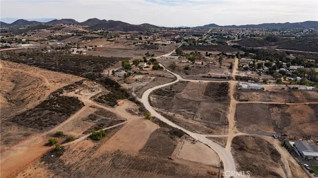 a view of a dry yard with wooden fence