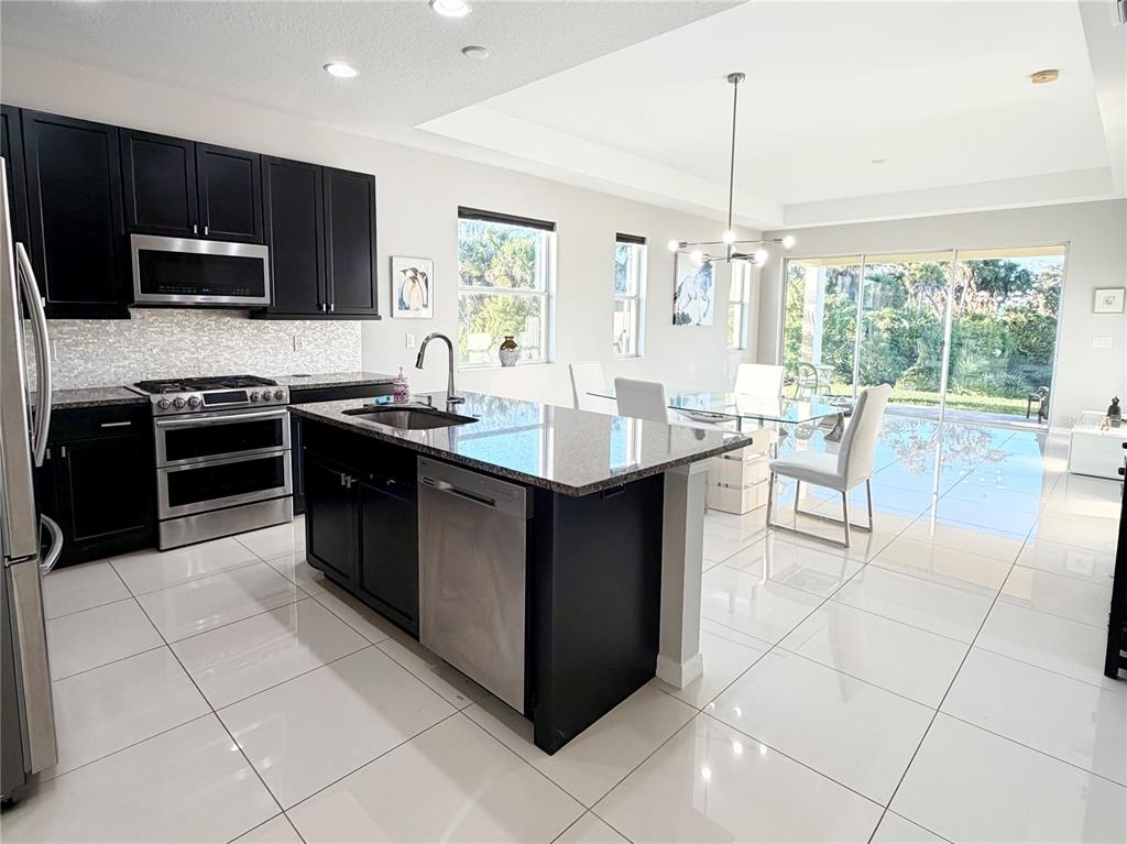 3105 Trustee Avenue Sarasota, FL 34243 - Photo 3 of 19 a kitchen with stainless steel appliances granite countertop a stove a sink and a microwave