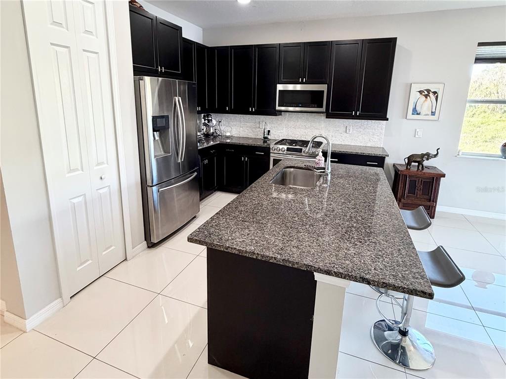 3105 Trustee Avenue Sarasota, FL 34243 - Photo 4 of 19 a kitchen with stainless steel appliances granite countertop a refrigerator and a stove top oven