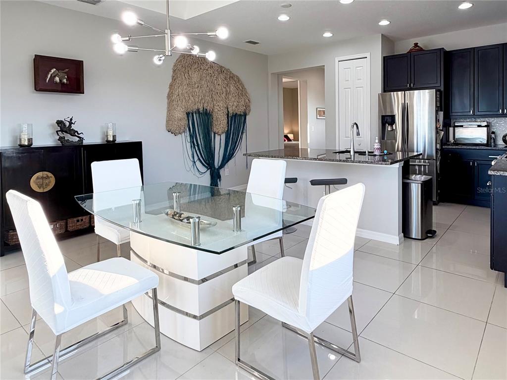 3105 Trustee Avenue Sarasota, FL 34243 - Photo 6 of 19 a kitchen with a dining table chairs and refrigerator