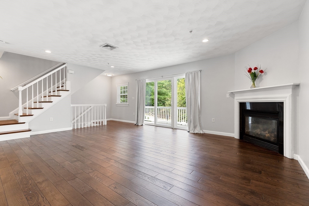 2 Ricciuti Drive, Unit 9 Quincy, MA 02169 - Photo 5 of 40 a view of an empty room with wooden floor and a fireplace
