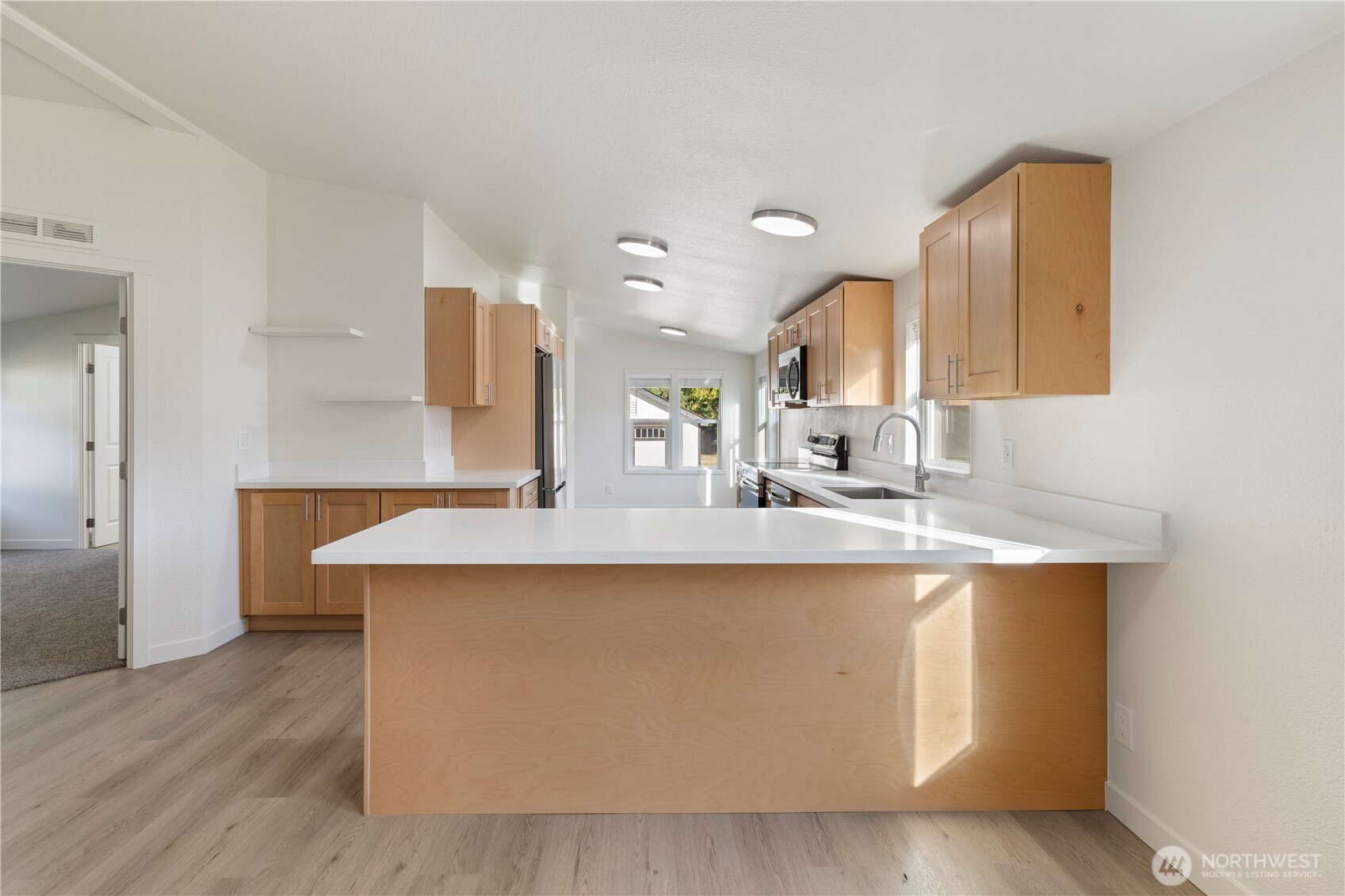 10324 Delphi Road Southwest, Unit 17 Olympia, WA 98512 - Photo 3 of 24 a large kitchen with kitchen island a sink stainless steel appliances and cabinets