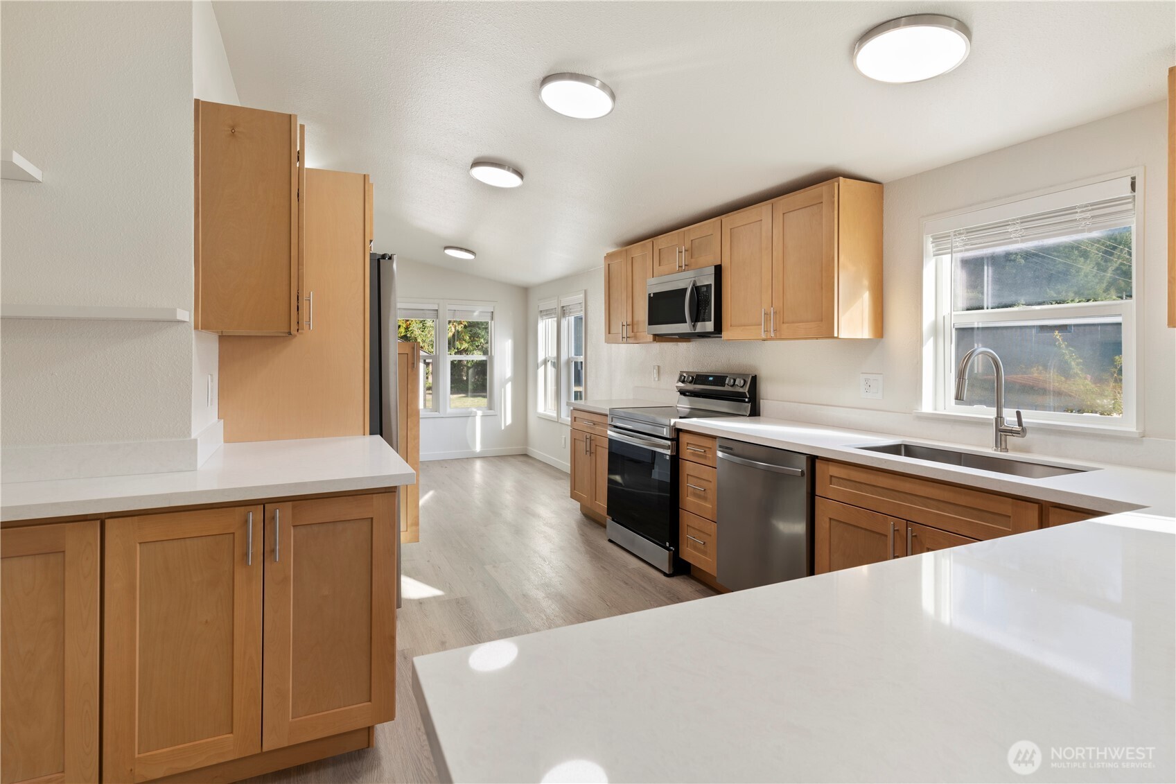 10324 Delphi Road Southwest, Unit 17 Olympia, WA 98512 - Photo 6 of 24 a kitchen with stainless steel appliances granite countertop a refrigerator a sink dishwasher a stove and white cabinets with wooden floor