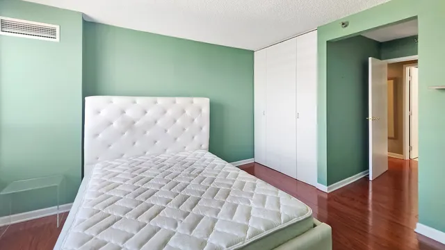 a bedroom with a bed and a wooden floor