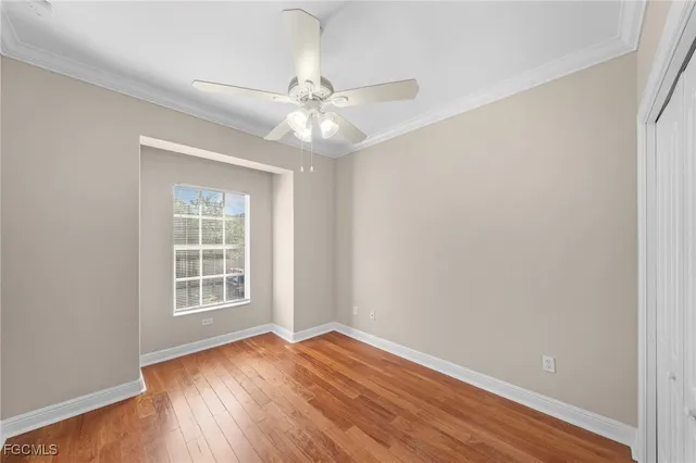 an empty room with a window and wooden floor