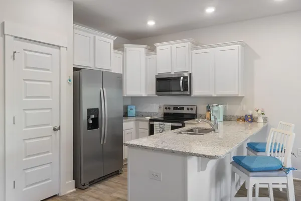 a kitchen with stainless steel appliances granite countertop a refrigerator stove microwave and cabinets