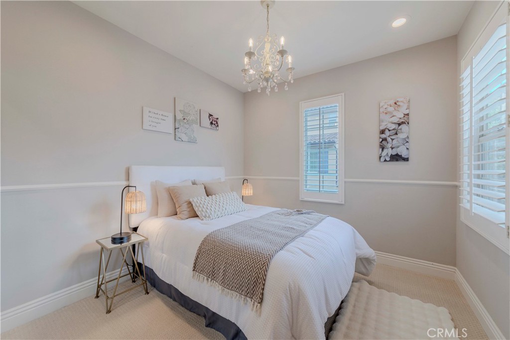 140 Full Moon Irvine, CA 92618 - Photo 16 of 38 a bedroom with a large bed and a chandelier