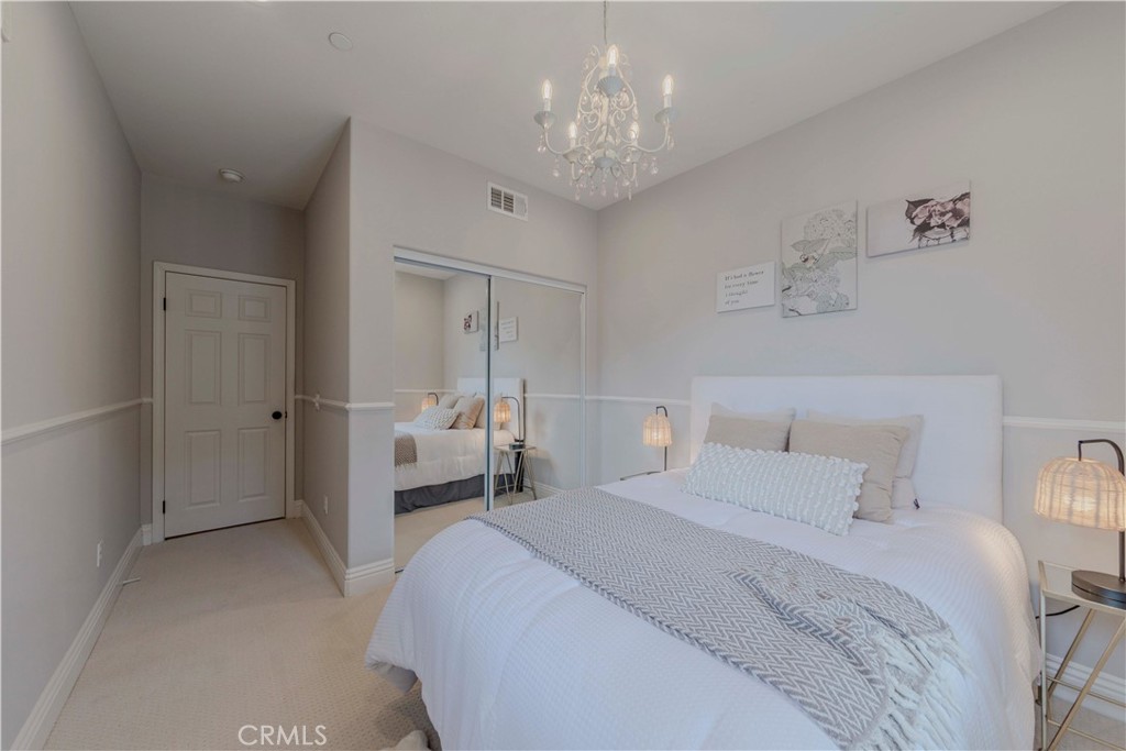 140 Full Moon Irvine, CA 92618 - Photo 17 of 38 a bedroom with a bed and a chandelier