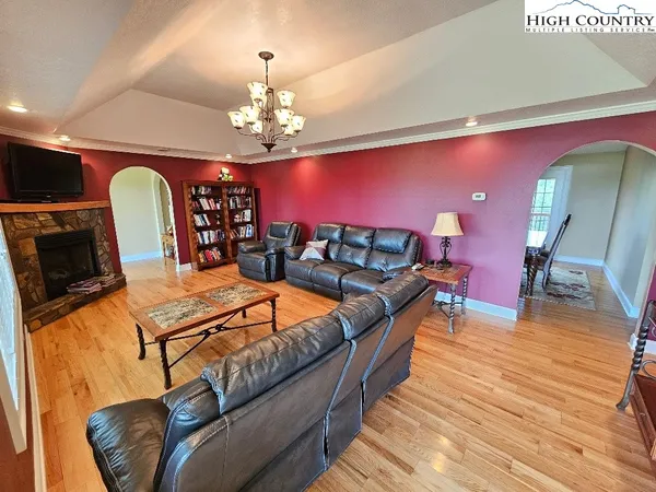 a living room with furniture a fireplace and wooden floor