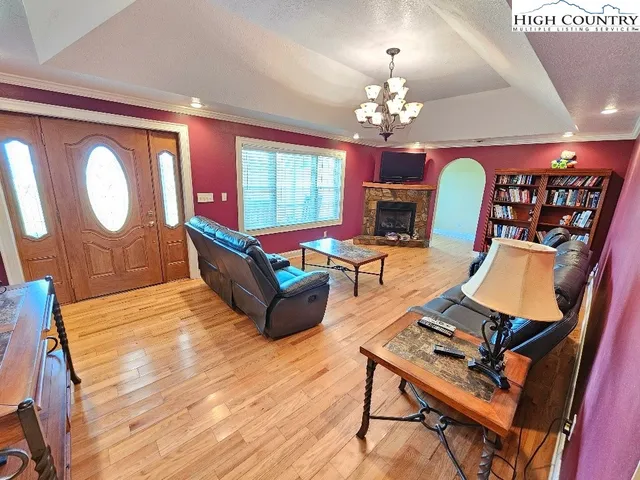 a living room with furniture a chandelier and a flat screen tv