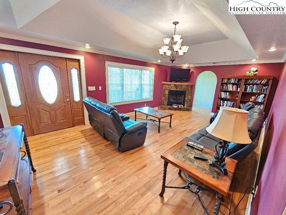 611 Barrett Road Ennice, NC 28623 - Photo 16 of 45 a living room with furniture a chandelier and a flat screen tv