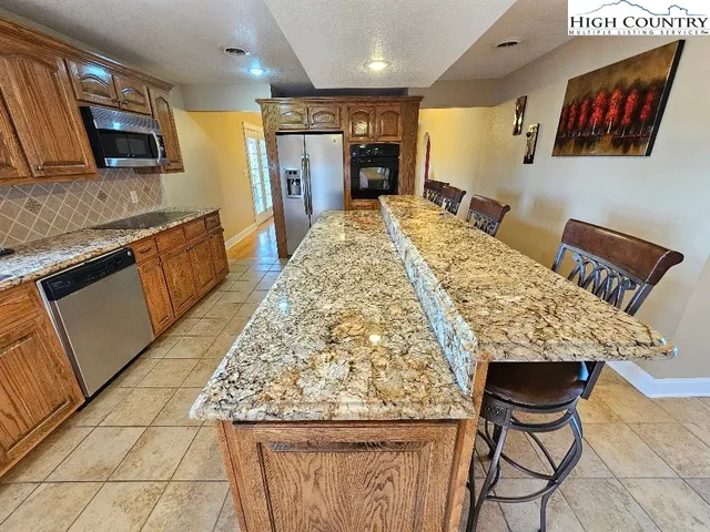 a living room with stainless steel appliances kitchen island granite countertop furniture and a kitchen view