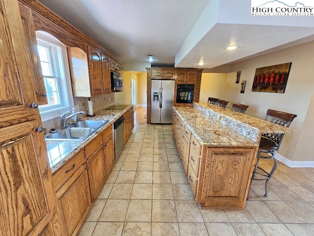 611 Barrett Road Ennice, NC 28623 - Photo 21 of 45 a large kitchen with kitchen island granite countertop a large counter top and appliances
