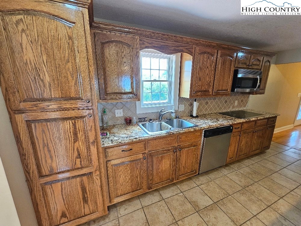 611 Barrett Road Ennice, NC 28623 - Photo 23 of 45 a kitchen with stainless steel appliances granite countertop a refrigerator and a sink