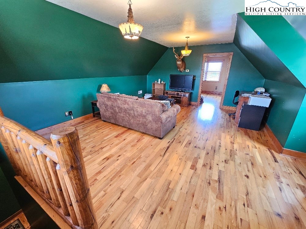 611 Barrett Road Ennice, NC 28623 - Photo 32 of 45 a spacious bedroom with a bed and a chandelier