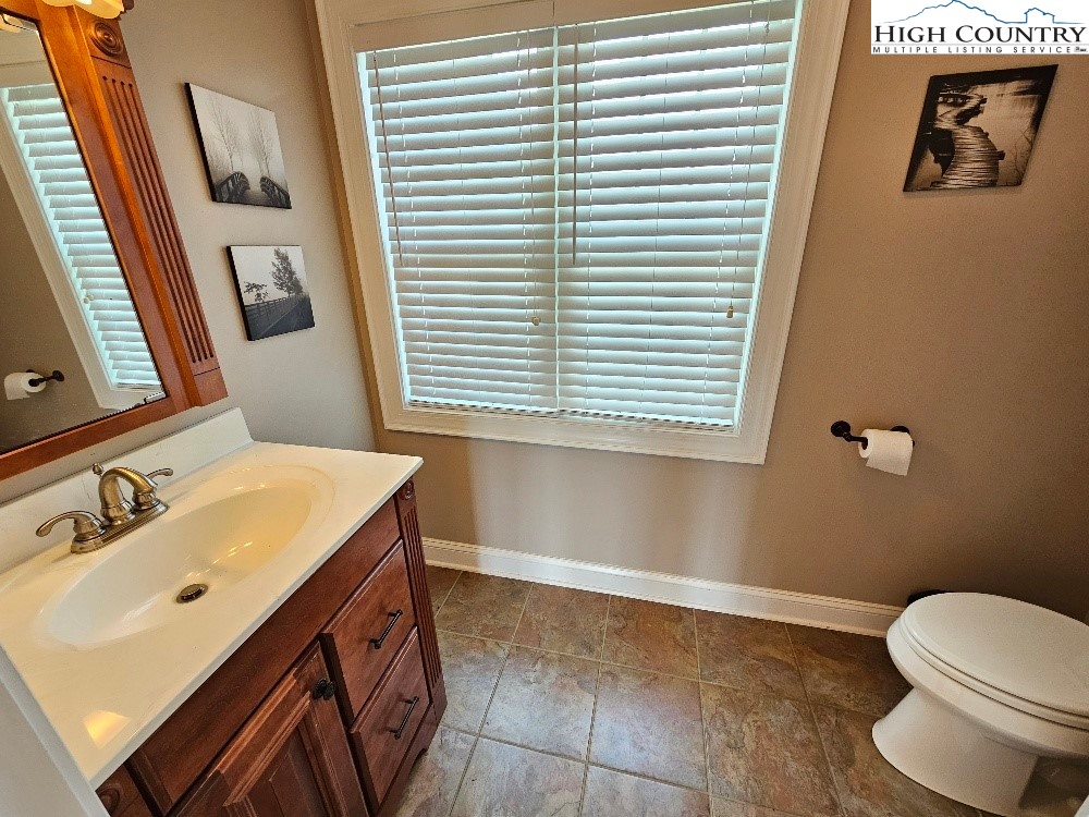 611 Barrett Road Ennice, NC 28623 - Photo 35 of 45 a bathroom with a sink a toilet and a mirror