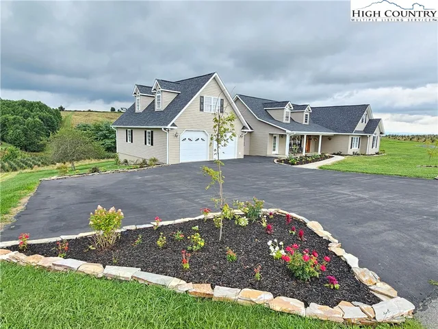 a front view of a house with a yard and a garden