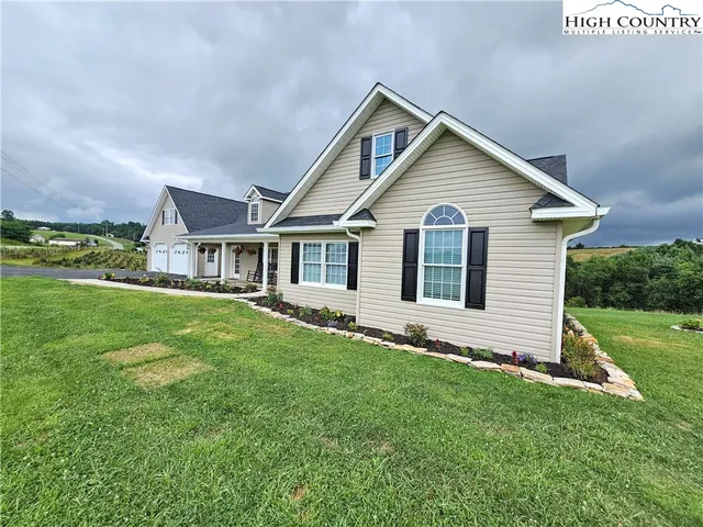 a view of a house with a yard and porch