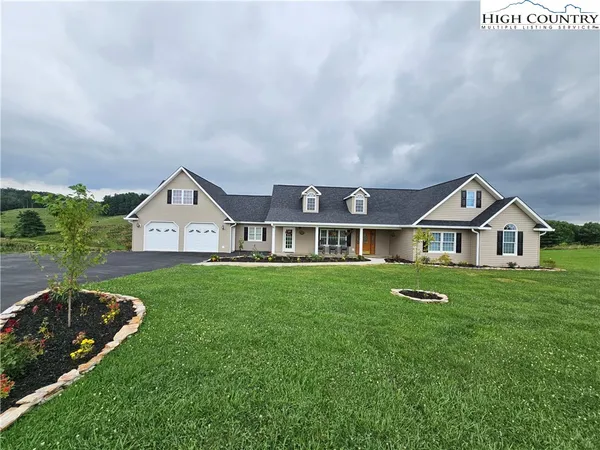 a view of a big house with a big yard potted plants and large tree