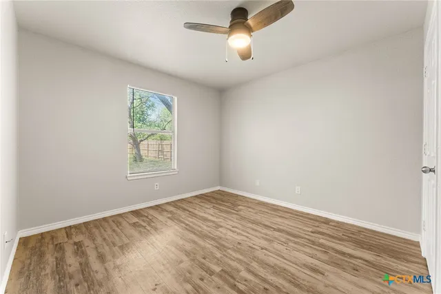 wooden floor in an empty room with a window
