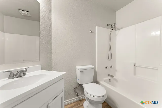 a bathroom with a sink toilet vanity and shower