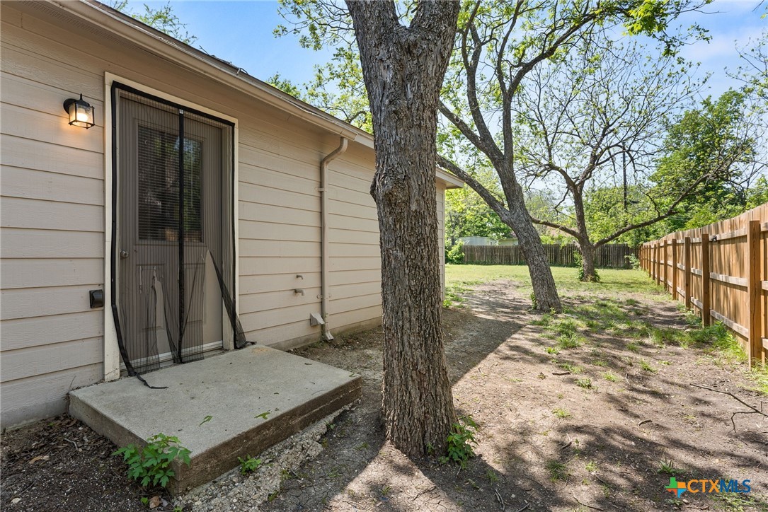 820 North 14th Street Temple, TX 76501 - Photo 20 of 23 a small yard with a table and chair under an trees