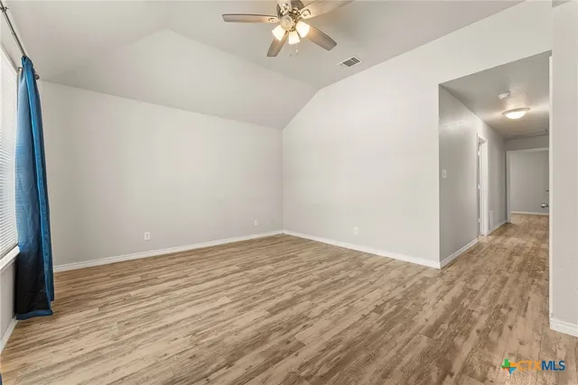 a view of an empty room with wooden floor