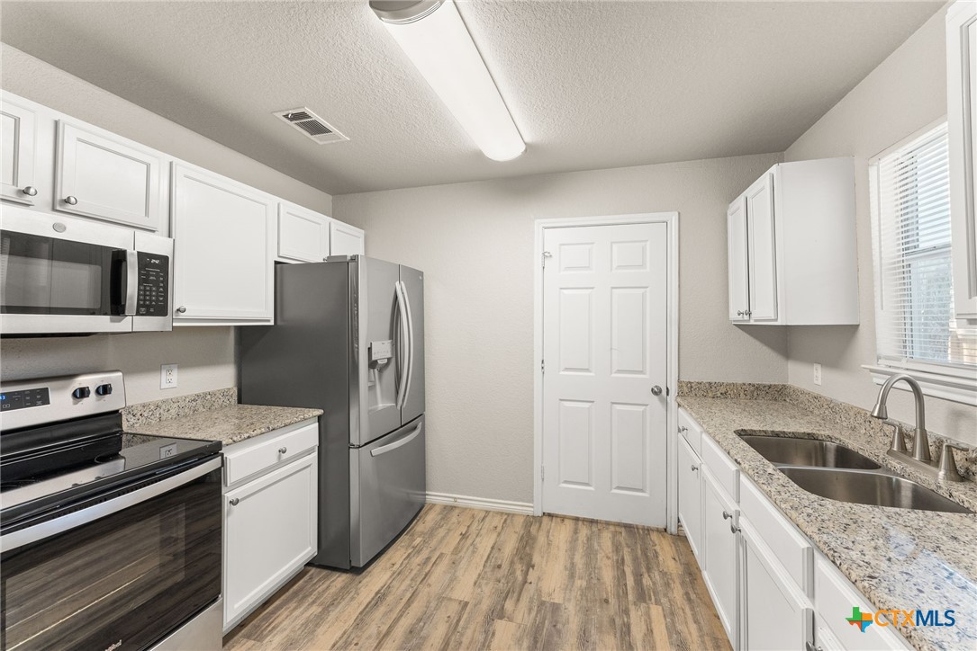 820 North 14th Street Temple, TX 76501 - Photo 8 of 23 a kitchen with granite countertop a refrigerator stove and sink