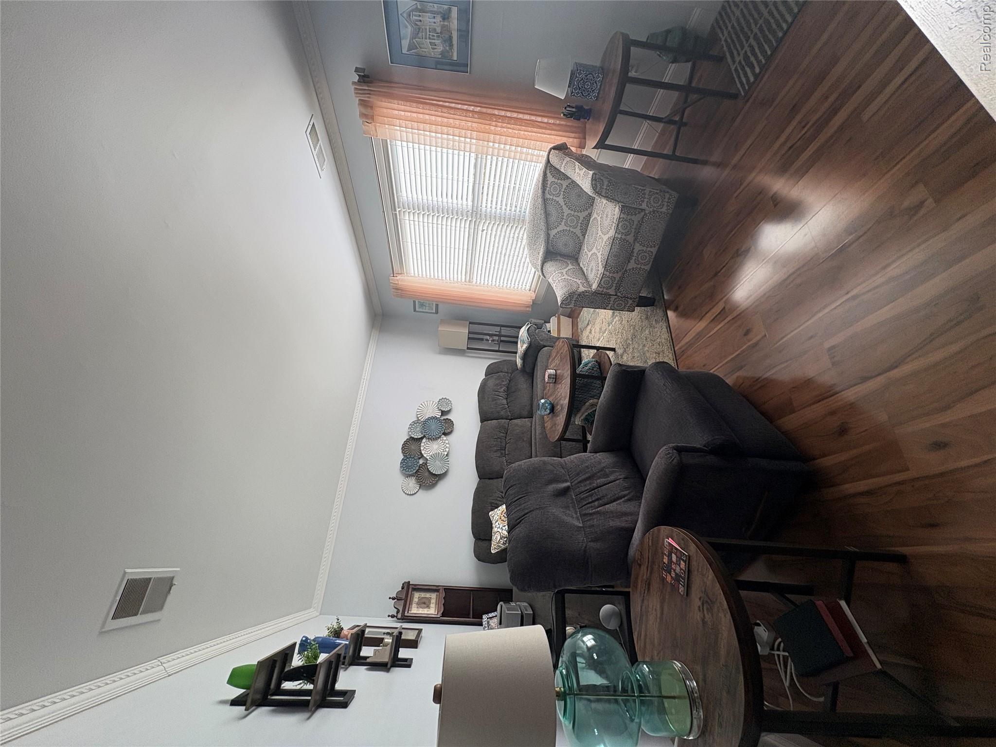 1030 Larson Court Rochester, MI 48307 - Photo 9 of 21 Living area with crown molding and dark wood finished floors