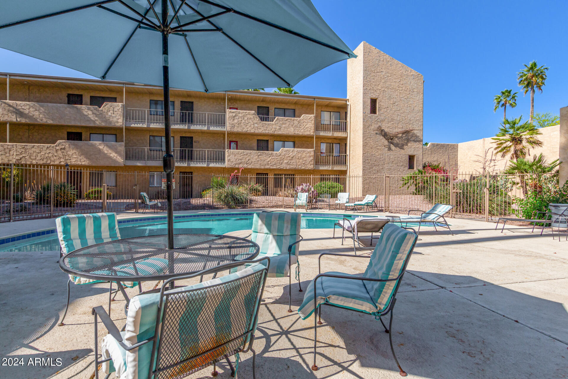 4950 North Miller Road, Unit 347 Scottsdale, AZ 85251 - Photo 19 of 31 a patio with a table and chairs under an umbrella