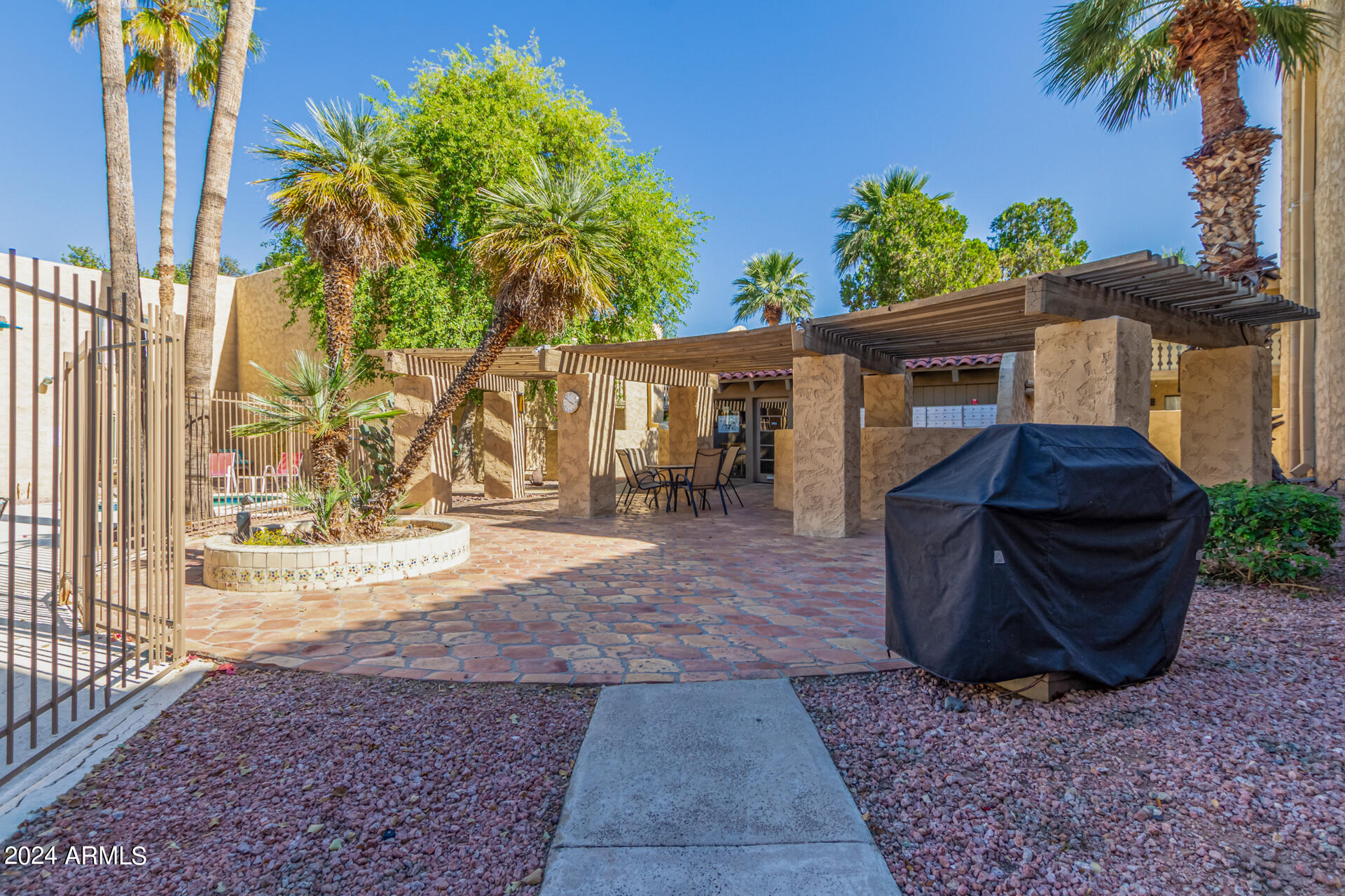 4950 North Miller Road, Unit 347 Scottsdale, AZ 85251 - Photo 24 of 31 a backyard of a house with barbeque oven table and chairs