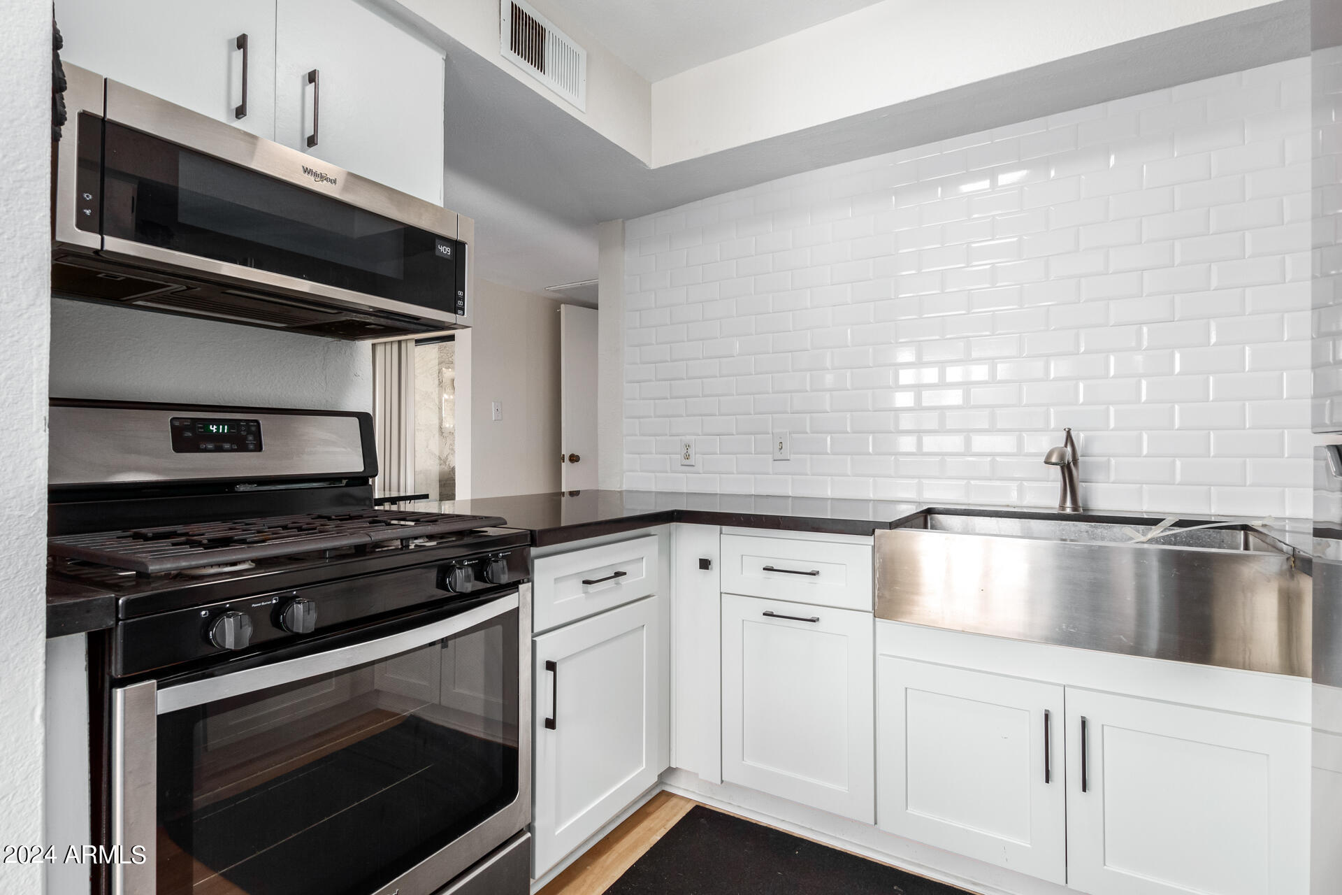 4950 North Miller Road, Unit 347 Scottsdale, AZ 85251 - Photo 9 of 31 a kitchen with granite countertop a stove and a sink