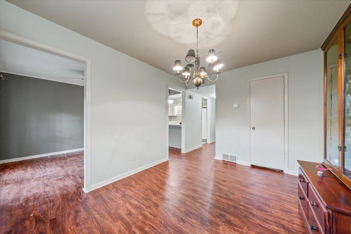 875 South Yates Road, Unit 4 Memphis, TN 38120 - Photo 11 of 25 Unfurnished dining area with dark wood finished floors and a chandelier