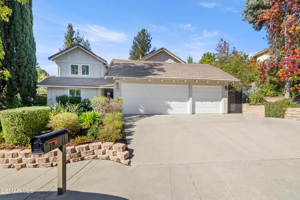 a front view of a house with a yard and potted plants