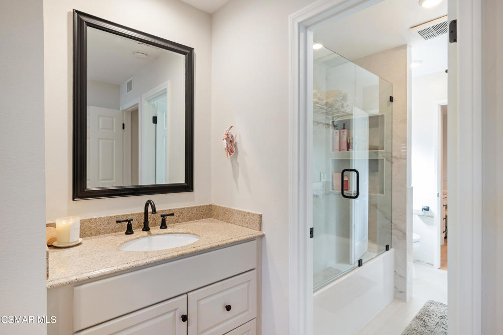 885 Rim Crest Drive Westlake Village, CA 91361 - Photo 15 of 35 a bathroom with a granite countertop sink a mirror a vanity and shower