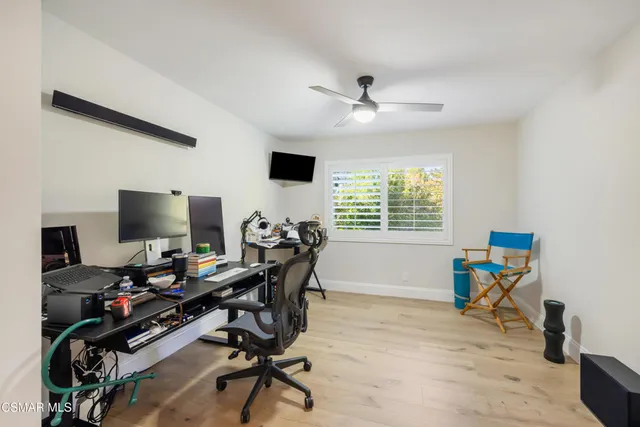 a view of a workspace with furniture and a window