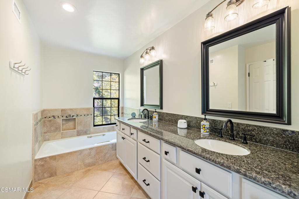 885 Rim Crest Drive Westlake Village, CA 91361 - Photo 29 of 35 a spacious bathroom with a granite countertop double vanity sink a mirror and a bathtub
