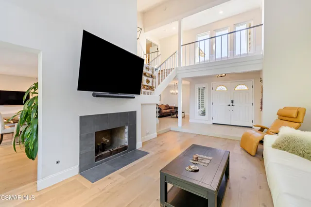 a living room with furniture a flat screen tv and a fireplace