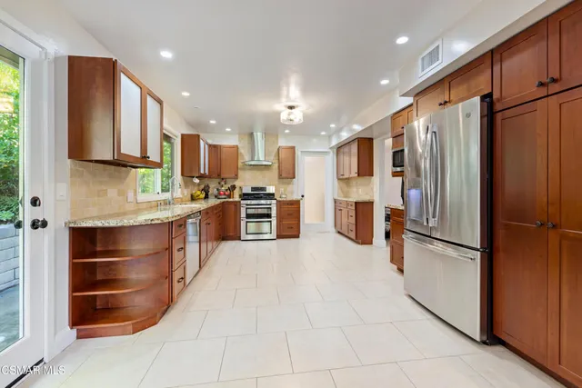 a kitchen with stainless steel appliances a refrigerator and a stove top oven