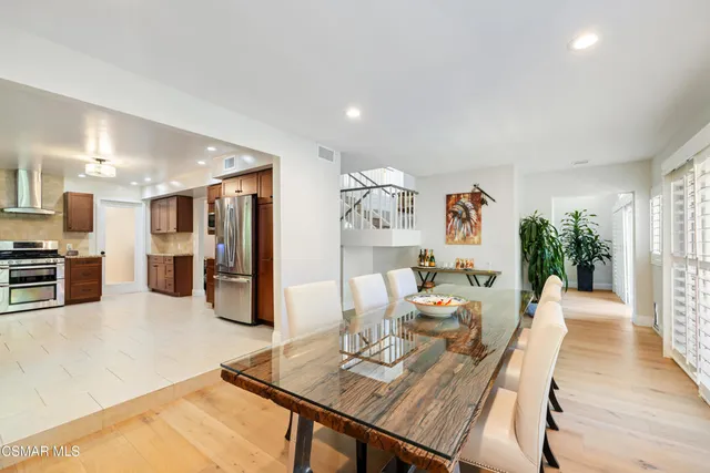 a living room with furniture and kitchen view with wooden floor