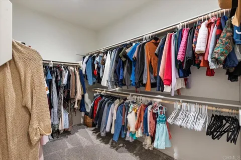 a view of walk in closet with clothes