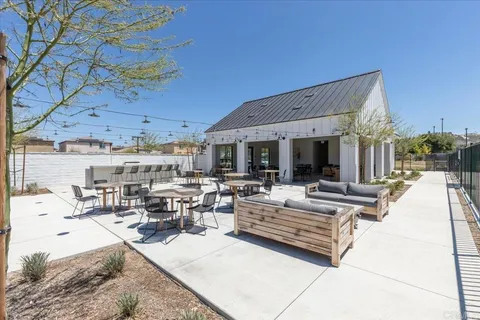 a view of a patio with dining table and chairs with a barbeque grill and plants