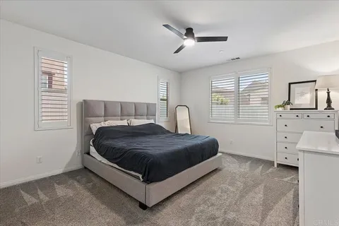 a bedroom with a bed a chandelier and a window